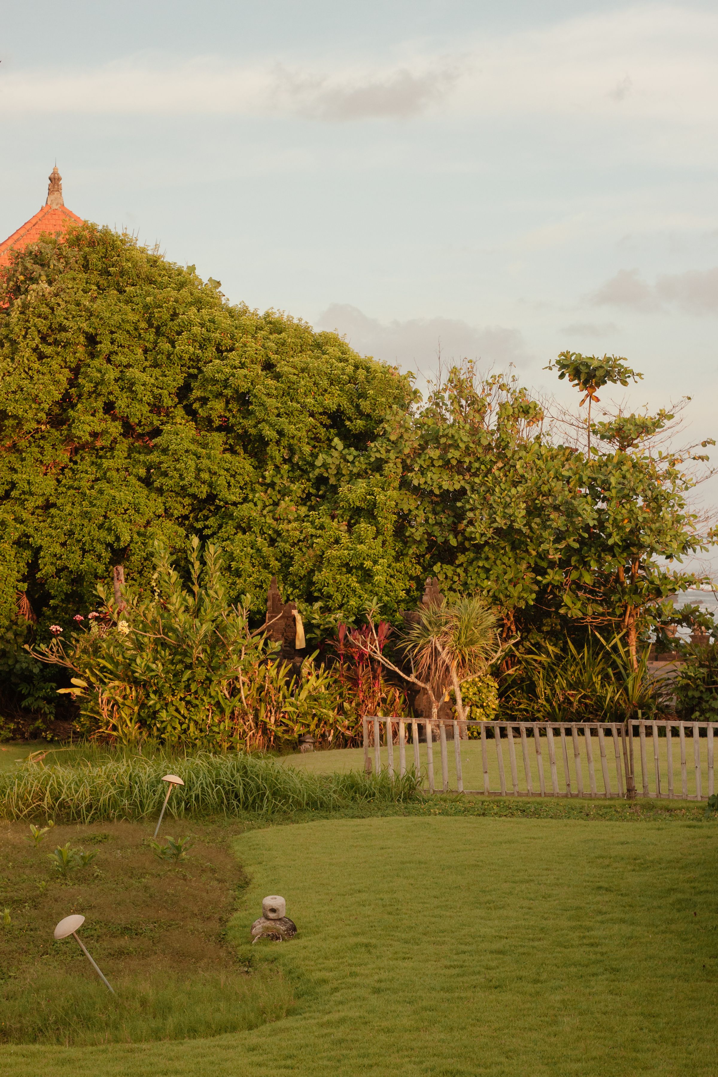 Lush green lawn bordered by colorful planting beds and mature trees